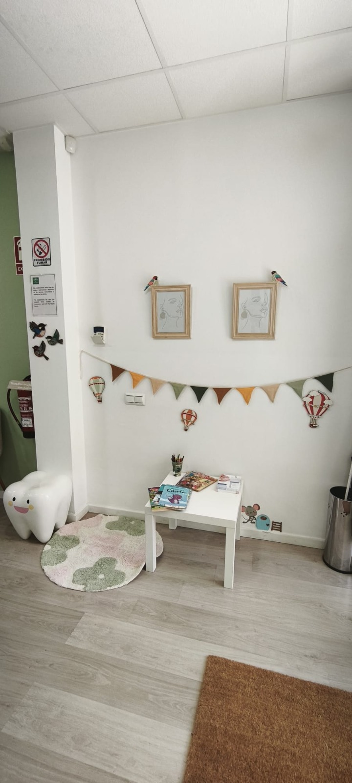 Zona infantil de Aljariz Dental con muñeco diente y área de juegos para niños